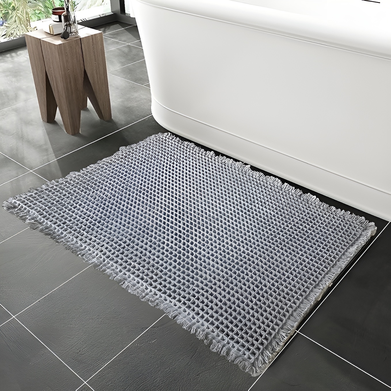 Gray bath mat by bathtub